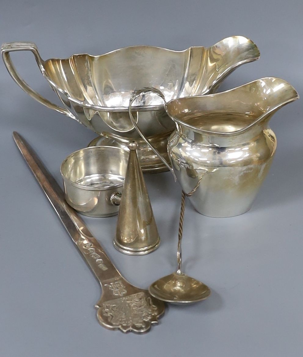 An American sterling sauceboat, a silver cream jug, a modern silver commemorative letter opener and three other items.